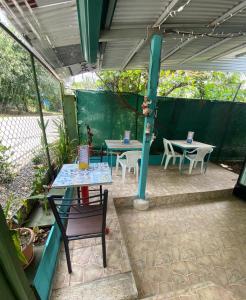a patio with two tables and a blue pole at Casa Natalia in Herradura
