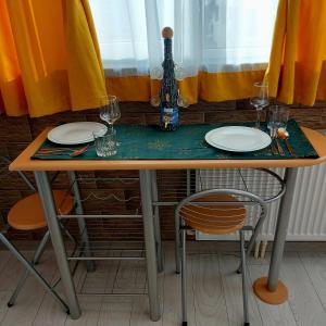a table with two plates and glasses on top of it at Dayana Home in Râmnicu Vâlcea