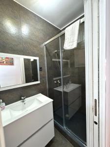 Apartment carrer d'Olesa في برشلونة: حمام مع دش ومغسلة ومرحاض