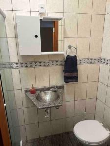 a bathroom with a sink and a toilet at Melhor localização de Floripa. in Florianópolis