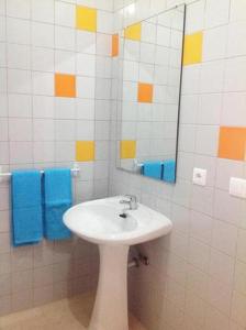La salle de bains blanche est pourvue d'un lavabo et d'un miroir. dans l'établissement O Sardinhas, à Matosinhos