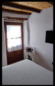 1 dormitorio con cama, puerta y ventana en Appartamento Su Piricocco - La casa dei ricordi, en Triei