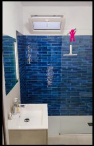 Triei的住宿－Appartamento Su Piricocco - La casa dei ricordi，浴室配有水槽和蓝色瓷砖墙。