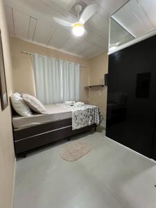 een kleine slaapkamer met een bed en een raam bij Suite 3- Nud Praia bonita Hospedagem in São Francisco do Sul