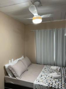 サン・フランシスコ・ド・スルにあるSuite 3- Nud Praia bonita Hospedagemの天井ファン付きの客室のベッド1台分です。