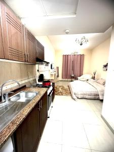 - une cuisine avec évier et un lit dans une chambre dans l'établissement Your Dubai delight, à Dubaï