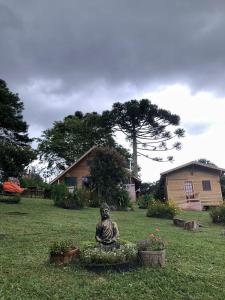 Une statue assise dans la cour d'une maison dans l'établissement cabanas luar, à São Francisco de Paula