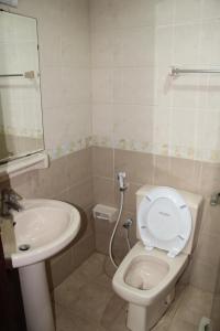 La salle de bains est pourvue de toilettes blanches et d'un lavabo. dans l'établissement Your Dubai delight, à Dubaï