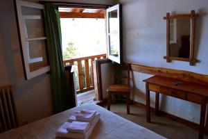 a room with a bed and a desk and a window at Hotel Angostura in Villa La Angostura