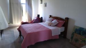 una camera con un letto e una coperta rosa di Casa ALGABELLA ad Ángeles