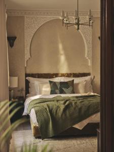 a bedroom with a large bed with a large headboard at IZZA Marrakech in Marrakech