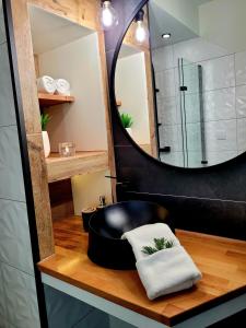 a bathroom with a black chair and a mirror at HAFCIK Apartamenty przyjazne dzieciom in Poronin