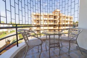 two chairs and a table on a balcony with a building at 3 bedroom Nyali apartment in Mombasa