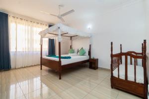 a bedroom with two beds and a ceiling fan at 3 bedroom Nyali apartment in Mombasa