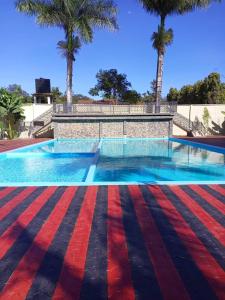 a swimming pool with palm trees in the background at Lush Garden Camping in Arusha