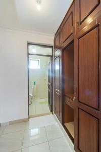 a bathroom with a wooden door and a walk in shower at 3 bedroom Nyali apartment in Mombasa