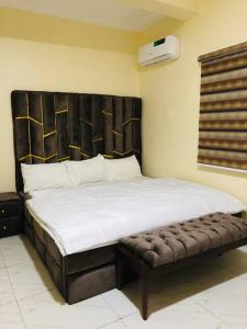 1 dormitorio con 1 cama grande y cabecero de madera en Furnished 2bedroom Apt in Wuye, en Wupa