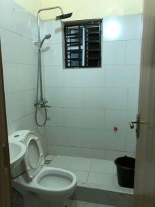 Baño blanco con aseo y lavamanos en Furnished 2bedroom Apt in Wuye, en Wupa