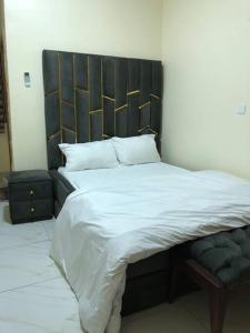 a large bed with a black headboard in a bedroom at Furnished 2bedroom Apt in Wuye in Wupa
