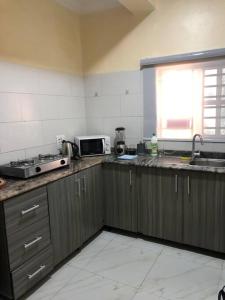 cocina con fregadero y microondas en Furnished 2bedroom Apt in Wuye, en Wupa