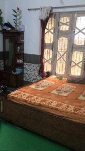 a bedroom with a large bed with windows at POP Ain Ul Noor Homestay in Thanna Mandi