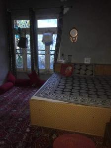 a large bed in a room with a clock on the wall at SPOT ON Malik Homestay in Thanna Mandi