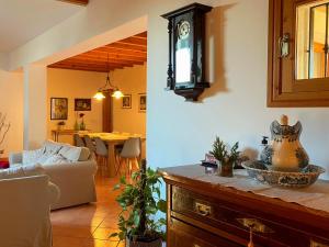 a living room with a couch and a clock on the wall at Casa rural, finca rústica con piscina Cas Padrins de Campos, Mallorca in Campos