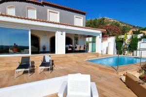 une villa avec une piscine et une maison dans l'établissement Villa avec piscine vue mer cumbre del sol LA CASA V, à Cumbre del Sol