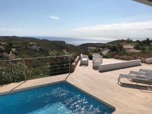 - une piscine sur une terrasse avec vue sur l'océan dans l'établissement Villa avec piscine vue mer cumbre del sol LA CASA V, à Cumbre del Sol
