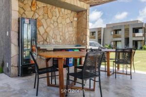 Une table et des chaises en bois sont disponibles sur la terrasse. dans l'établissement Apto relaxante próximo a Praia do Patacho CVPE102, à Porto de Pedras