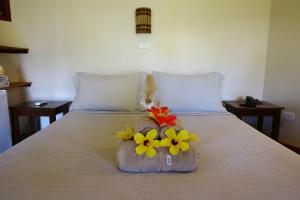 a bed with a basket with flowers on it at Pousada Lagoa do Cassange in Marau