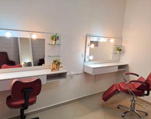 een salon met 2 stoelen en een spiegel bij Pousada TOP in Mairiporã