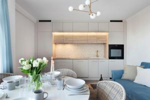 a living room with a table and a couch at Elite Apartments Sandy in Gdańsk
