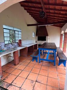 - une cuisine avec des bancs et une table dans une pièce dans l'établissement Rancho das Flores, à Tatuí