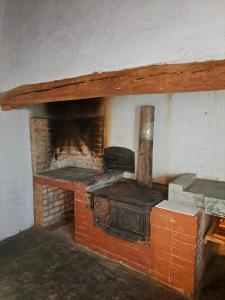 a brick fireplace with a stove in a room at Goedgeloof Farm Stay in Barrydale