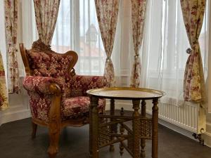 uma cadeira e uma mesa em frente a uma janela em Salve Teplice em Teplice