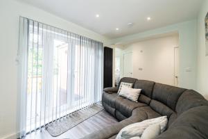 a living room with a couch and a large window at Modern 4-Bed Retreat with Garden in Manchester