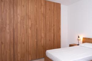 a bedroom with wooden walls and a bed at Azure FOUR in Żurrieq