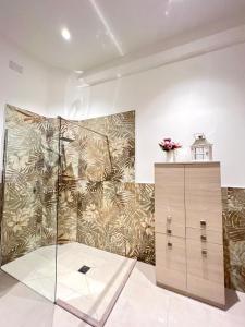 baño con ducha y pared con papel pintado en Aristocasa B&B luxury rooms en Palermo