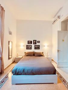 a white bedroom with a large bed in a room at Aristocasa luxury rooms in Palermo