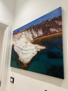 a painting of a beach on a wall at Aristocasa luxury rooms in Palermo