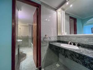 y baño con lavabo, espejo y ducha. en Hotel Olimpia en Ostende