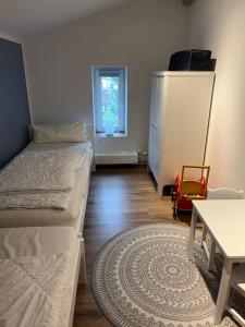 a room with two beds and a table and a small window at Wohnung Utkiek - Alte Schule in Glowe
