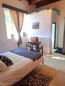 a bedroom with a bed and a table in a room at Goedgeloof Farm Stay in Barrydale