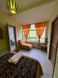sypialnia z 2 łóżkami, kanapą i oknem w obiekcie Habitación privada con terraza panorámica, cocina, parqueadero w Baños