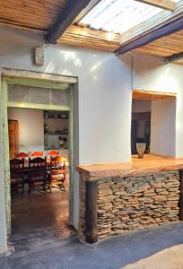a room with a stone counter and a dining room at Goedgeloof Farm Stay in Barrydale