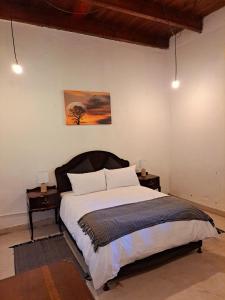 a bedroom with a large bed with two night stands at Goedgeloof Farm Stay in Barrydale