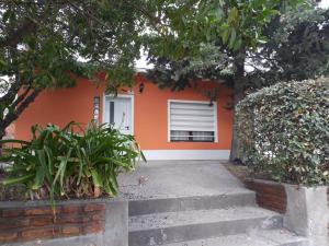 una pequeña casa naranja con escaleras delante en Casa Shanti en Monte Hermoso