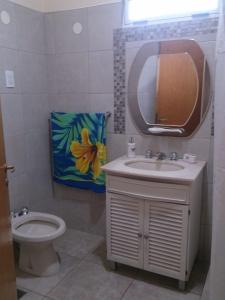 y baño con aseo, lavabo y espejo. en Casa Shanti en Monte Hermoso