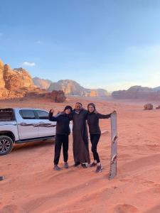 een groep mensen die poseren voor een foto in de woestijn bij Shakria Bedouin Life Camp in Wadi Rum